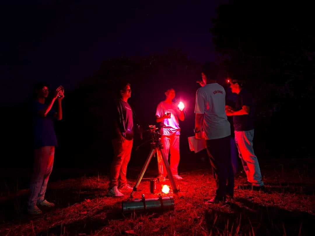 Olympiad students setting up a telescope at night